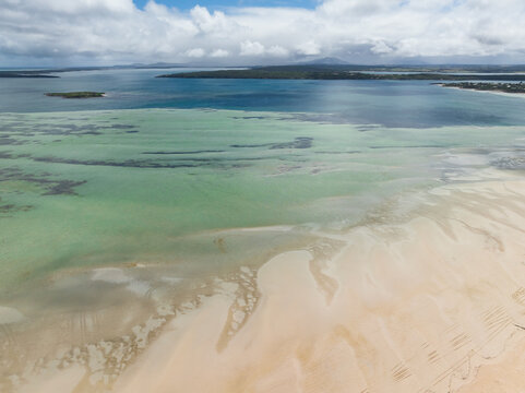 Aerial view of patterns on tidal sand flats along a calm ocean bay