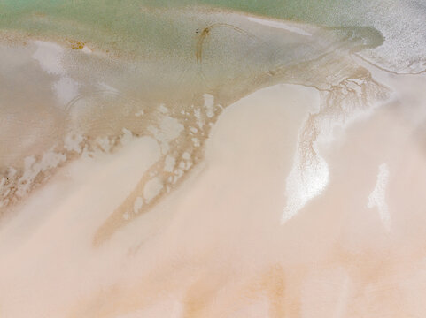 Aerial view of abstract patterns of tidal sand flats along a wide sandy beach