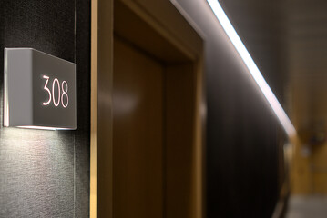  Close-up of a hotel room number, illuminated by soft lighting, showing a modern and sleek room design.