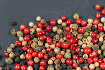 A mixture of different peppercorns white, black, red and green peppers spices.