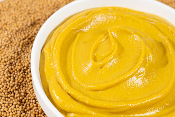 Mustard sauce and dry mustard seeds close-up