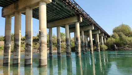 Fototapeta premium The columns of a reinforced concrete road bridge over a river
