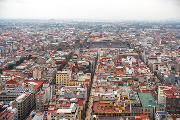 Obraz premium Elevated view of the Mexico City Centre towards the Plaza de la Constitución, known as the Zocalo, with major buildings such as the Cathedral and the Palacio Nacional on a cloudy day