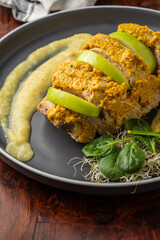 Aerial view of roast turkey stuffed with apple and mustard on a wooden table, vertical, with copy space