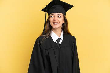 Young university graduate isolated on yellow background thinking an idea while looking up