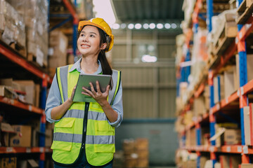 Warehouse workers using a digital tablet while recording inventory. Logistics employees working with warehouse management software in a large distribution centre.