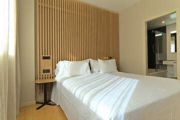 Bright Hotel Room with Wooden Decor and Direct Bathroom View
