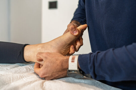 : Osteopath performing ankle and foot manipulation during professional treatment session - Powered by Adobe