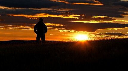 Fototapeta premium Silhouetted Figure Watching Captivating Sunset in the Countryside