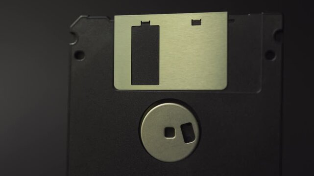 Close up of old floppy disks. Vintage data storage on diskette. Flexible disk of a magnetic storage medium in a square plastic enclosure. Smooth sliding and panning motion