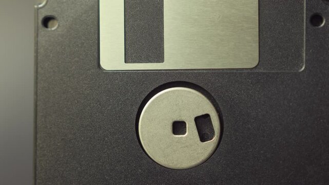 Close up of old floppy disks. Vintage data storage on diskette. Flexible disk of a magnetic storage medium in a square plastic enclosure. Smooth sliding and panning motion