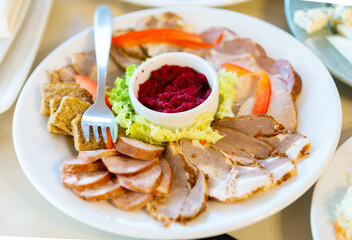 A Delicious and Colorful Platter of Cold Cuts With Fresh Vegetables and a Dip on a White Plate