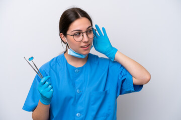 Dentist caucasian woman holding tools isolated on white background listening to something by...