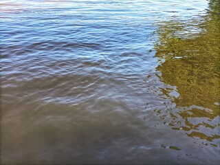 You can see the ripples of a large river and the shadows of trees