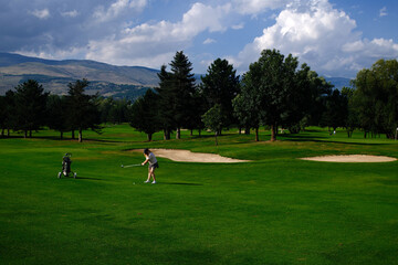 woman playing golf on the green fairway course