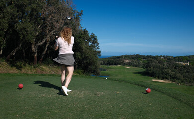 woman playing golf on the green fairway course