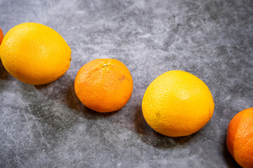 Orangen und Mandarinen in einer Reihe, diagonal, Hintergrund grau