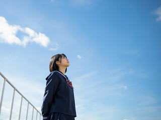 青空を見上げる女子学生, 制服