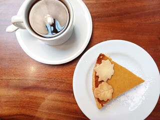 Postre de pastel de calabaza con una taza de café. Toma superior.