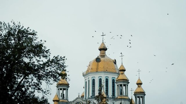 Tample against sky with birds circling around. A disturbing scene with birds