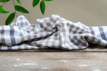 The checkered napkin is lying on a wooden table.