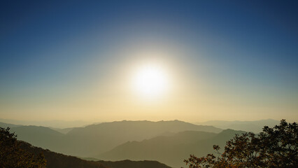 Sunlight is dispersed in the atmosphere. At sunset, the sky becomes yellow or gold. The mountains look like an oriental painting.