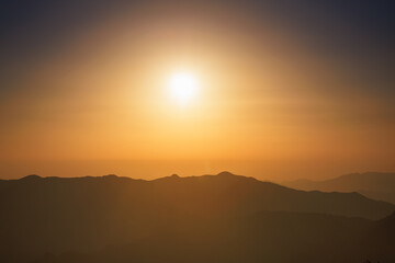 Sunlight is dispersed in the atmosphere. At sunset, the sky becomes yellow or gold. The mountains look like an oriental painting.