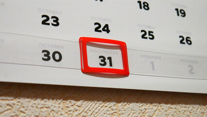 Close-up of a red frame cursor on Halloween date of a wall calendar October page