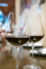 Two glasses of red wine on the table, with blur background in the restaurant