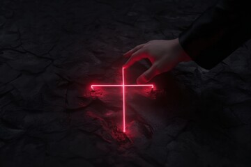 Hand reaches for glowing red cross on dark stone surface