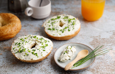 Breakfast table with bagels fresh cheese.