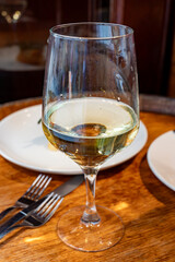 Glass of txakoli or chacolí slightly sparkling very dry white wine produced in Spanish Basque Country in typical pinchos bar in old part of San Sebastian or Donostia, Spain