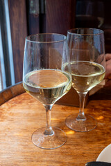 Glass of txakoli or chacolí slightly sparkling very dry white wine produced in Spanish Basque Country in typical pinchos bar in old part of San Sebastian or Donostia, Spain