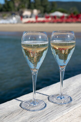 Summer time in Provence, two glasses of cold champagne cremant sparkling wine on famous Pampelonne sandy beach near Saint-Tropez in sunny day, Var department, France, beach club party