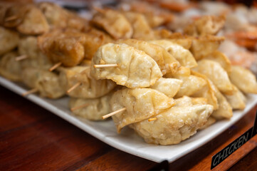 Typical snack of Basque Country, pinchos or pinxtos skewers with small pieces of bread, sea food, eggs, cheese, jamon served in bar in San-Sebastian or Bilbao, Spain, close up