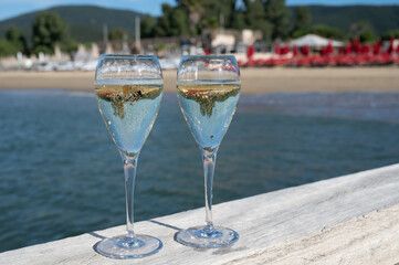 Summer time in Provence, two glasses of cold champagne cremant sparkling wine on famous Pampelonne sandy beach near Saint-Tropez in sunny day, Var department, France, beach club party