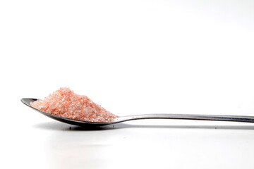 a spoonful of himalayan salt, isolated on a white background