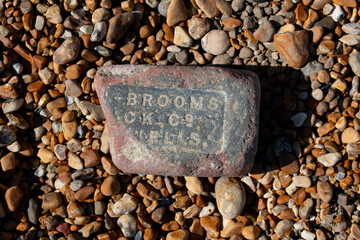 text old stone brickwork washed up on pebble beach 