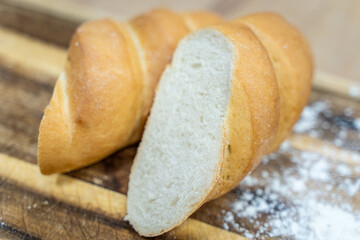 A loaf of sourdough bread on a wooden table, in a cut. a loaf of artisan bread.