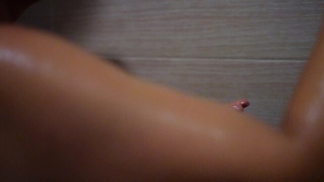 Mujer poniendo shampoo en la mano para ba&ntilde;arse