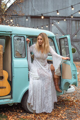 American blonde Woman in long white lace Boho dress with sleeves and fringe, fashionable outfit...