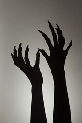 Black silhouette two hands reaching up towards sky Clawed
