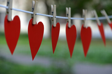Heart shaped paper Pink color hanging on a rope with copy space for text Valentine's Day concept