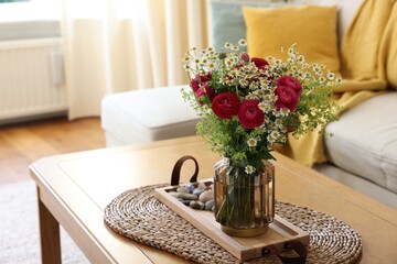 Beautiful ranunculus flowers and chamomiles in vase on table indoors. Space for text
