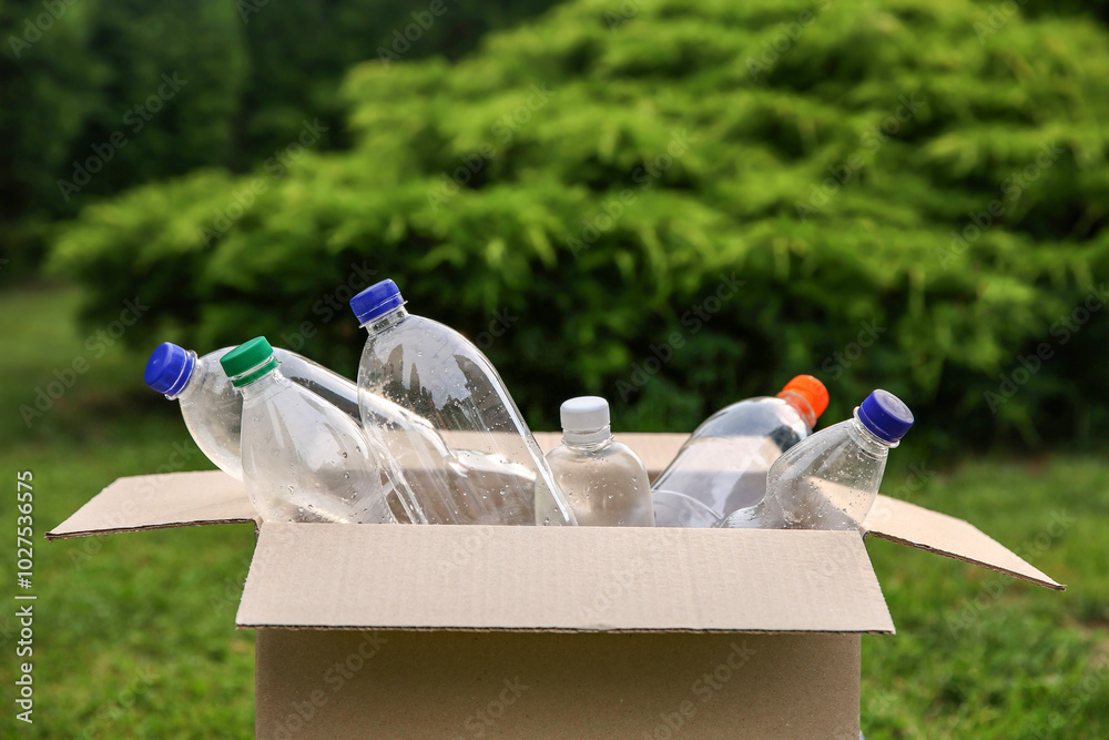 Sticker Recycling. Plastic bottles in cardboard box outdoors