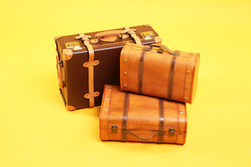 Three different closed suitcases on yellow background