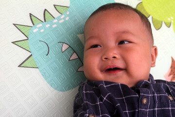 adorable asian baby boy sleeping on mattress
