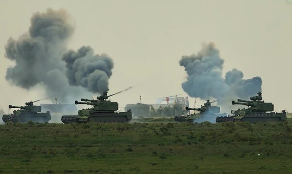 Soldiers Firing M777 Howitzers in Open Field