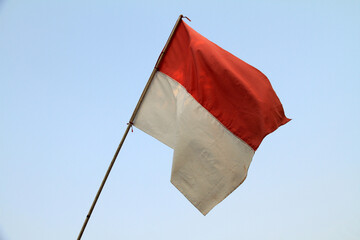 the red and white flag, the Indonesian flag installed on the fence being exposed to the wind
