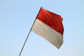 the red and white flag, the Indonesian flag installed on the fence being exposed to the wind
